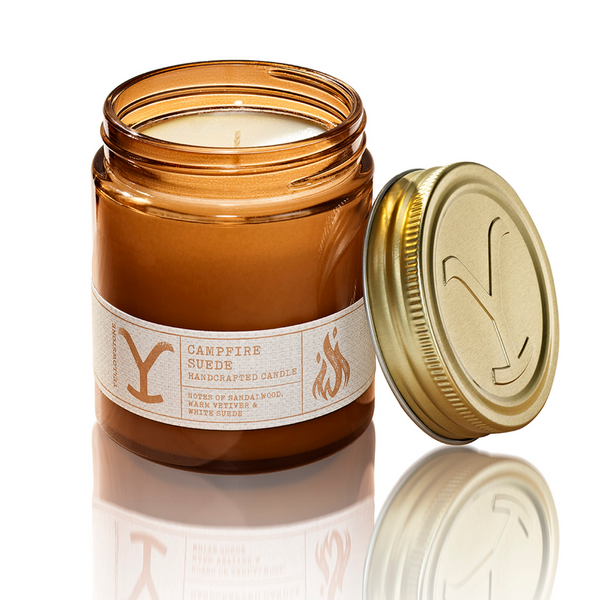 Candle in an amber jar with a gold lid on a white background