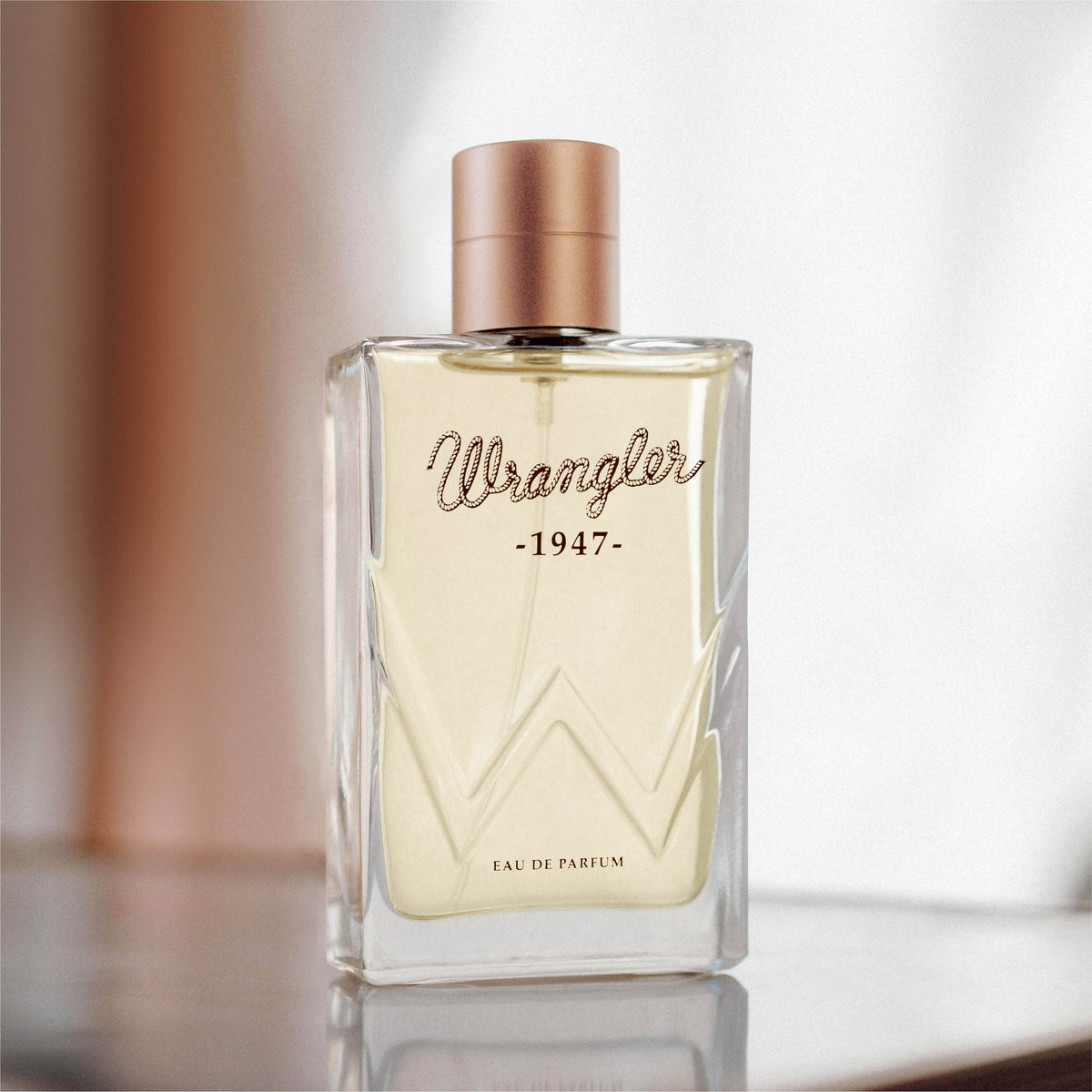Wrangler 1947 perfume bottle on a reflective surface with a blurred background